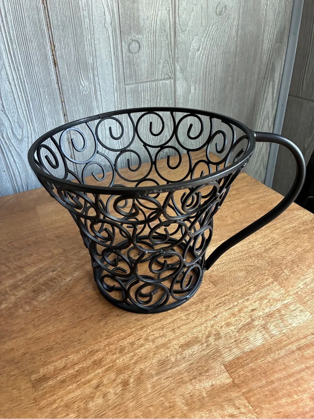 wrought iron decorative basket shaped like a large coffee mug or teacup,